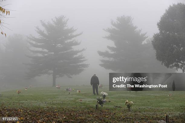 ThanksgivingGrave PHOTOGRAPHER: Carol Guzy DATE: Brooklyn MD Richard Martin visits the grave of his parents Ada and Roland Martin in a dense morning...