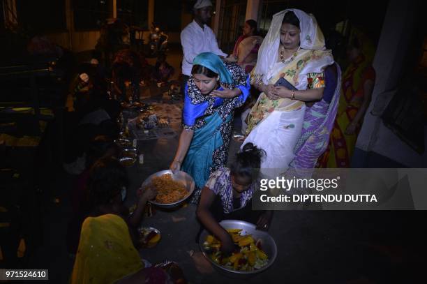 Indian social workers distributes food during Iftar to children and families who lives at Chetna Leprocy Centre in Siliguri on June 11, 2018. - Like...