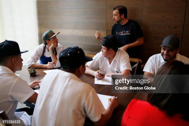 Joe Grafton of ReThink Restaurants, center, leads a business training class for Spanish-speaking employees as part of "open book" management training...