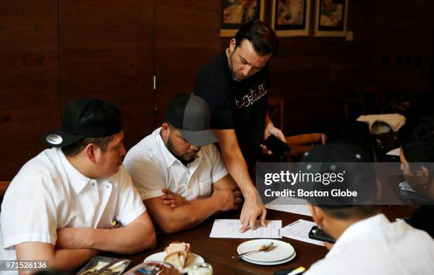 Joe Grafton, center, of ReThink Restaurants, leads a business training class for Spanish-speaking employees as part of "open book" management...