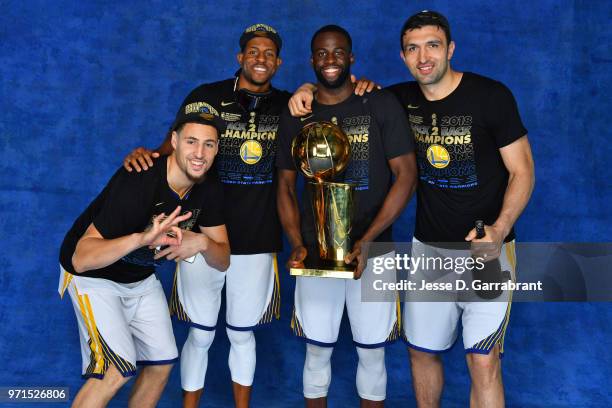 Klay Thompson, Andre Iguodala, Draymond Green and Zaza Pachulia of the Golden State Warriors pose for a portrait with the Larry O'Brien Trophy after...