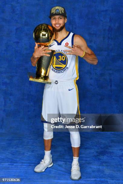 Stephen Curry of the Golden State Warriors poses for a portrait with the Larry O'Brien Trophy after winning Game Four of the 2018 NBA Finals against...