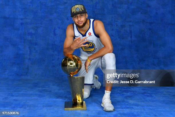 Stephen Curry of the Golden State Warriors poses for a portrait with the Larry O'Brien Trophy after winning Game Four of the 2018 NBA Finals against...