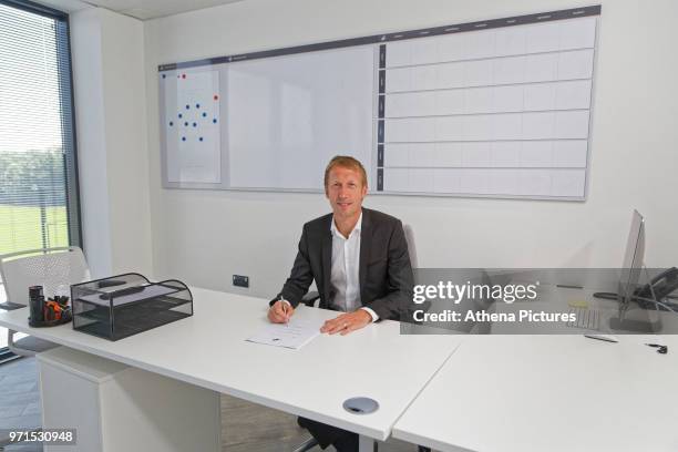 Graham Potter signs his contract in his office during the unveiling of the new manager Graham Potter at The Fairwood Training Ground on June 11, 2018...