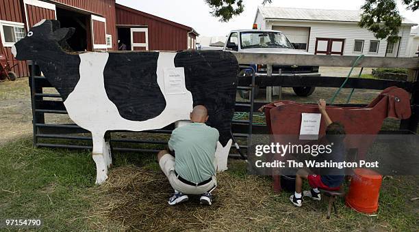 Kevin Clark\The Washington Post Neg #: 171138 Herndon, VA Carlos Auila, left, with son Miguel Auila practice their milking techniques at the Fairfax...