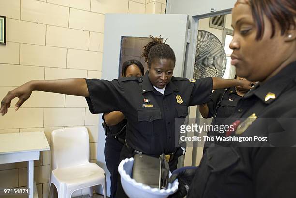 Kevin Clark/The Washington Post Neg #: clarkk208483 Jessup, MD Officer Shauna Heard is patted down before the start of her shift with Joanne Archie,...
