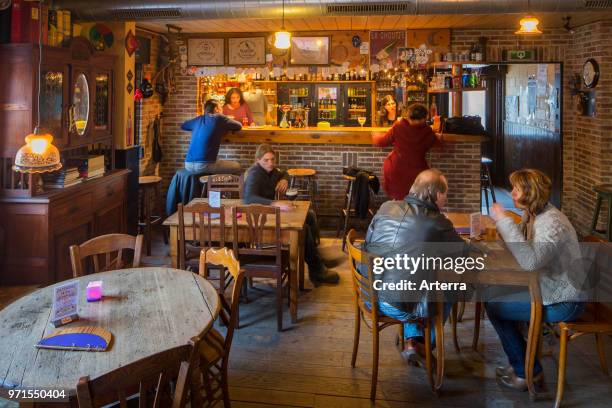 Flemish customers drinking beer in cafe De Betoverde Maan, Belgian pub in the village Dikkelvenne, Gavere, East Flanders, Belgium.