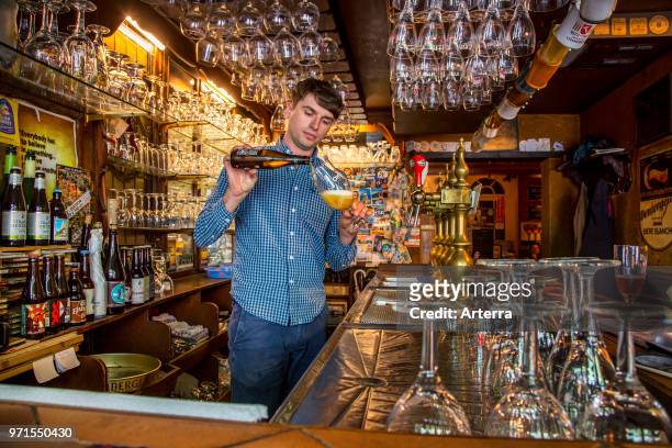 Bartender pouring Belgian beer in glass in Flemish cafe 't Brugs Beertje in Bruges / Brugge, West Flanders, Belgium.