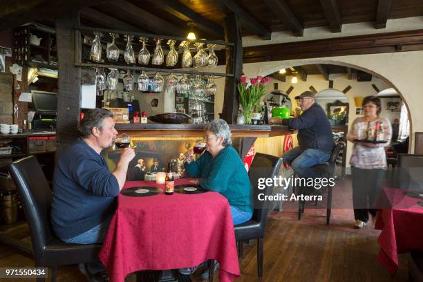 Elderly couple tasting Belgian abbey beers in cosy Flemish tavern De Kroon in the village Denderwindeke near Ninove, East Flanders, Belgium.