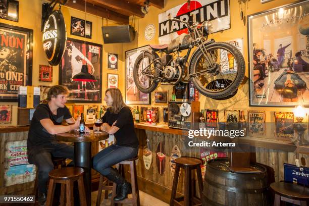 Two young customers drinking Belgian beer in the Flemish cafe Rock Circus in the city Ghent, East Flanders, Belgium.