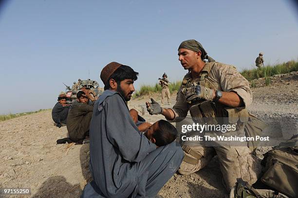 South Afghanistan U.S. Marine Christopher Brewer, 3rd Class Petty Officer United States Navy working with Charlie Company 2nd LAR diagnoses a child...