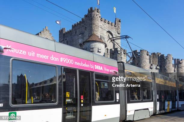 Tram of De Lijn in front of medieval Gravensteen / castle of the counts in the historic city centre of Ghent, East Flanders, Belgium.