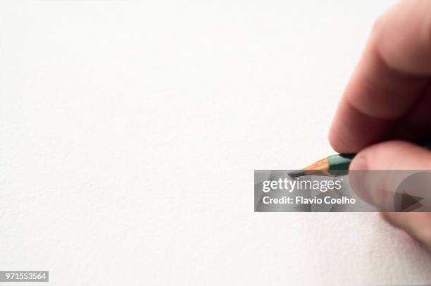 hand holding pencil touching a blank sheet of paper - sketch stock pictures, royalty-free photos & images