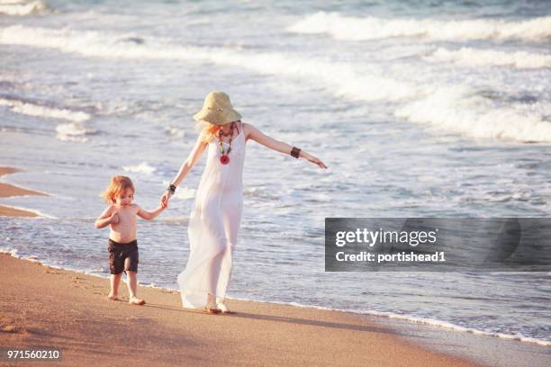 mother and child walking on the beach - portishead stock pictures, royalty-free photos & images