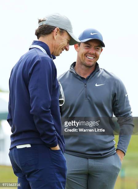 Rory McIlroy of Northern Ireland talks with Brad Faxon during practice rounds prior to the 2018 U.S. Open at Shinnecock Hills Golf Club on June 11,...
