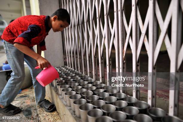 Nepalese Muslim kid putting juice on a glass for an Iftar dinner, the traditional Ramadan's fast-breaking meal at Kashmiri Takiya Jame mosque at...
