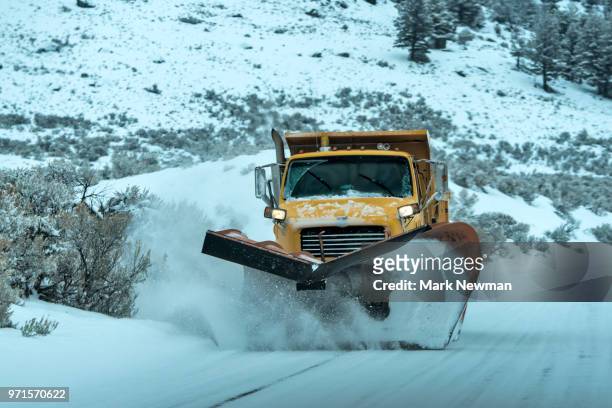 snowplow approaching on snowy road - sneeuwschuiver stockfoto's en -beelden