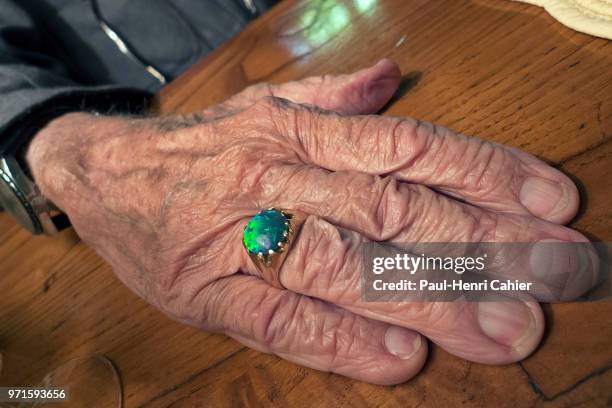 The hand and opal ring of legendary 94 year-old American photojournalist David Douglas Duncan , better known as DDD, at a restaurant with friends in...