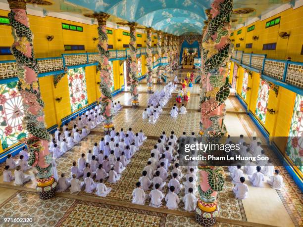 the cao dai faithful in cao dai holy see temple at morning prayer - cao dai temple stock pictures, royalty-free photos & images