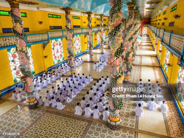 the cao dai faithful in cao dai holy see temple at morning prayer - cao dai temple stock pictures, royalty-free photos & images