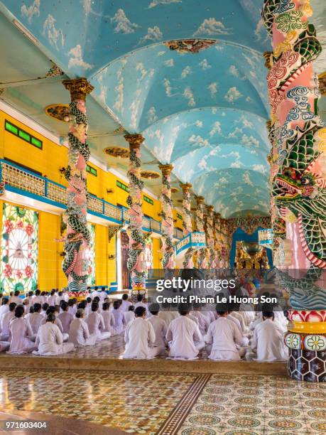 the cao dai faithful in cao dai holy see temple at morning prayer - cao dai temple stock pictures, royalty-free photos & images