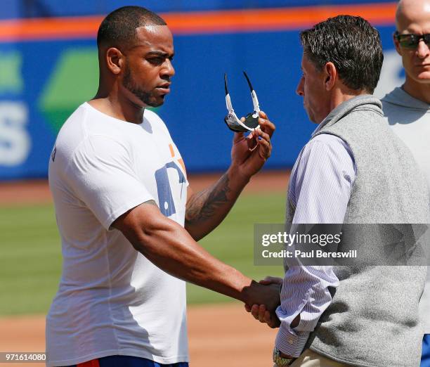 New York Mets chief operating officer Jeff Wilpon talks in the outfield with Yoenis Cespedes of the Mets as Cespedes works out as he recovers from a...