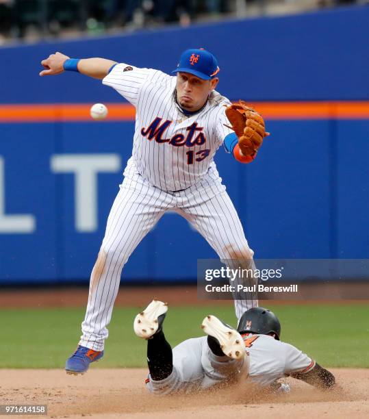 Asdrubal Cabrera of the New York Mets reaches for the throw but Craig Gentry of the Baltimore Orioles slides safely into second base with the steal...