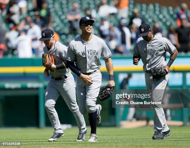 Right fielder Giancarlo Stanton of the New York Yankees smiles as he runs in from the outfield with left fielder Clint Frazier of the New York...