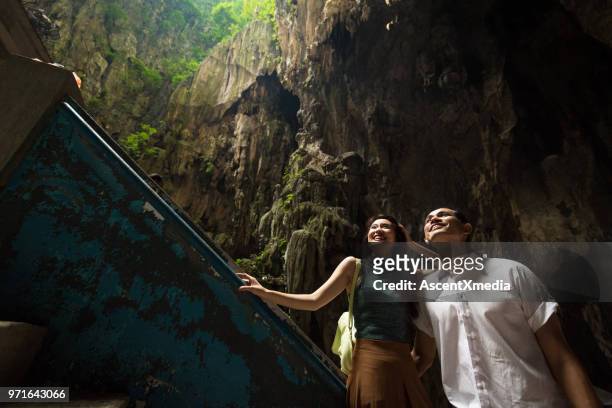 couple visiting the batu caves near kuala lumpur, malaysia - batu caves stock pictures, royalty-free photos & images