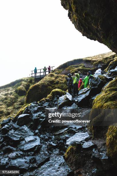 menschen am wasserfall seljalandsfoss in island - powerofforever stock-fotos und bilder