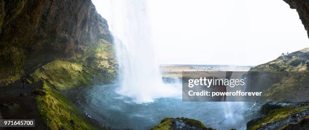 people at seljalandsfoss waterfall in iceland - powerofforever stock pictures, royalty-free photos & images