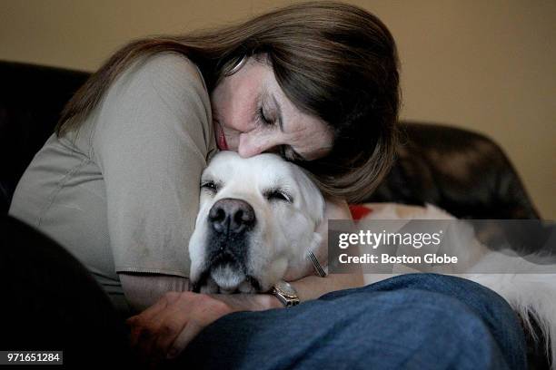 Louise Guy hugs her dog Blue in South Dartmouth, MA on June 1, 2018. Guy's former boyfriend Warren R. Broughton faces charges of assault and battery...