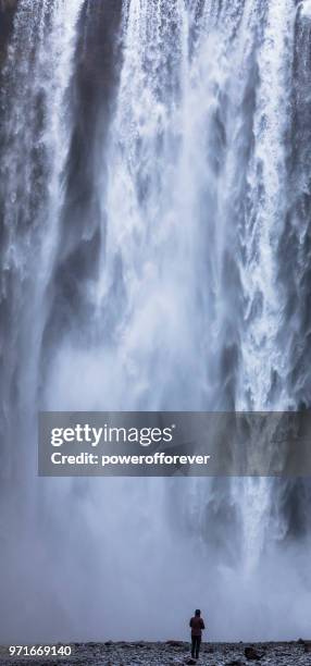 menschen bei skógafoss wasserfall in island - powerofforever stock-fotos und bilder