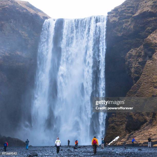 menschen bei skógafoss wasserfall in island - powerofforever stock-fotos und bilder