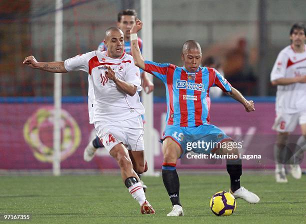 Takayuki Morimoto of Catania Calcio competes for the ball with Sergio Almiron of AS Bari during the Serie A match between Catania and Bari at Stadio...