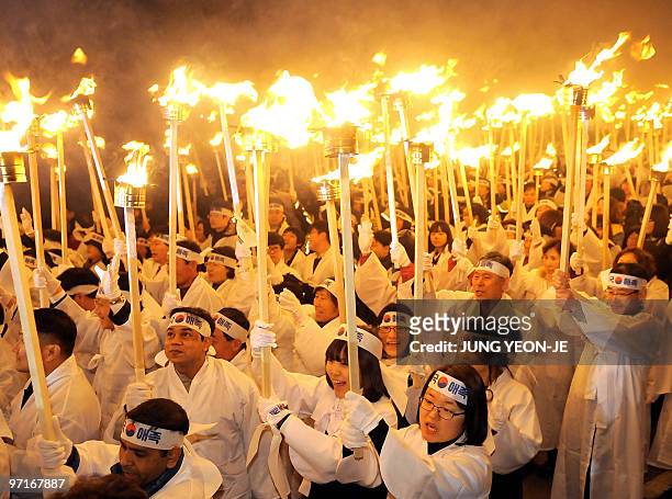 South Korean civilians wearing traditional costumes hold up burning toches to celebrate the March 1 Independence Movement Anniversary in Cheonan, 92...