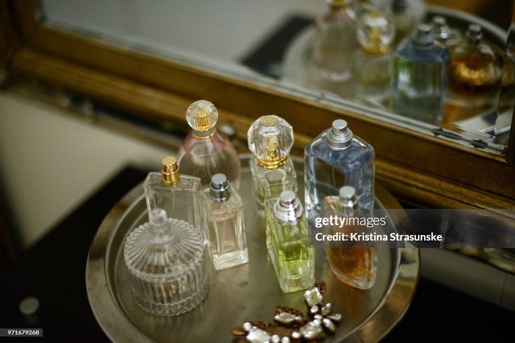 Perfume bottles on a tray by a mirror
