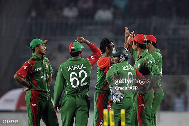 Bangladeshi cricketers celebrate the dismissal of unseen England cricketer Craig Kieswetter during the first One Day International cricket match...