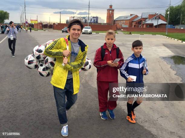 Russian teenagers carry a net with balls signed by Argentina's footballers after attending a training session of Argentina's national football team...