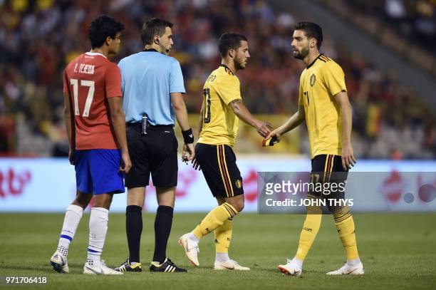 Belgium's forward Eden Hazard gives his captain's armband to Belgium's forward Yannick Ferreira-Carrasco as he leaves the football pitch during the...