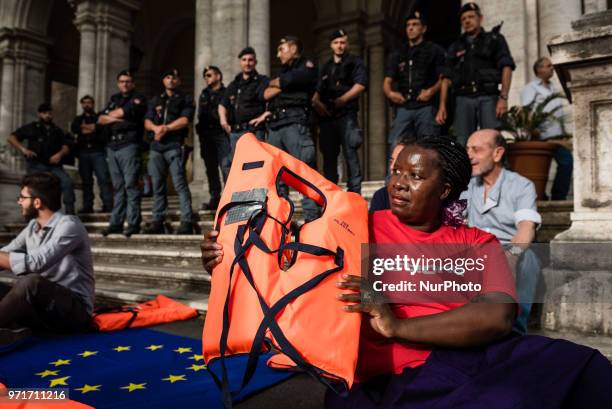 Woman holds a life jacket during a rally in Rome, Italy, on June 11, 2018 against Italian government decision to block ports to a German NGO ship...