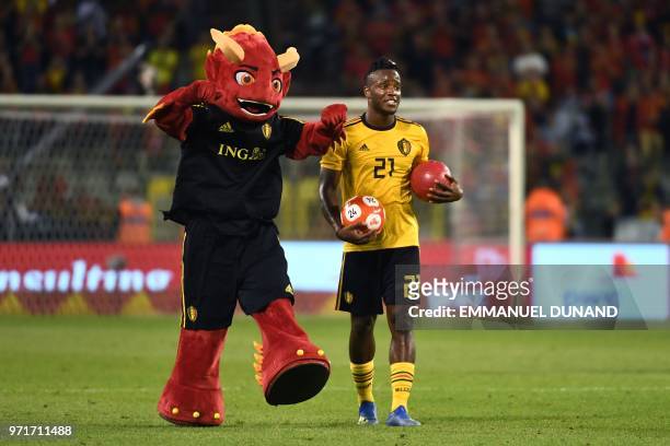 Belgium's forward Michy Batshuayi celebrates with the Red Devil Mascott at the end of the international friendly football match between Belgium and...