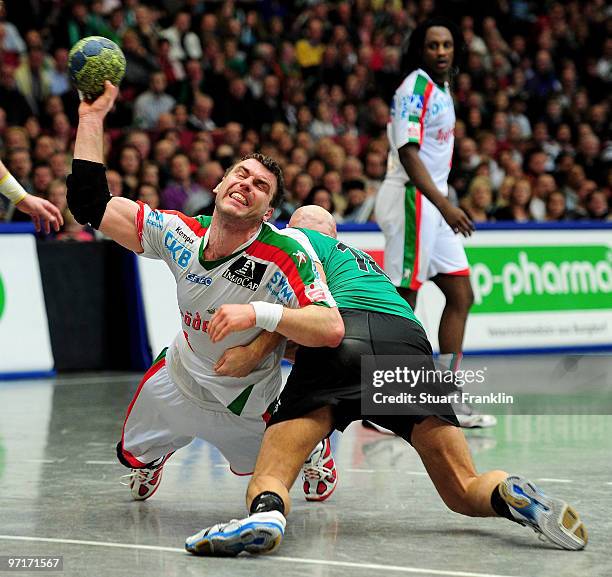 Bartosz Jurecki of Magdeburg is challenged by Robertas Pauzuolis of Hannover during the Toyota HBL match between TSV Hannover Burgdorf and SC...