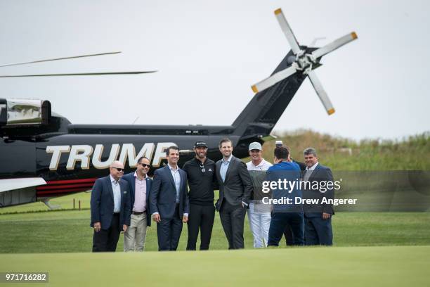 Gathered at center, Eric Trump and Donald Trump Jr. Pose for photos with professional golfer Dustin Johnson before a ribbon cutting event for a new...