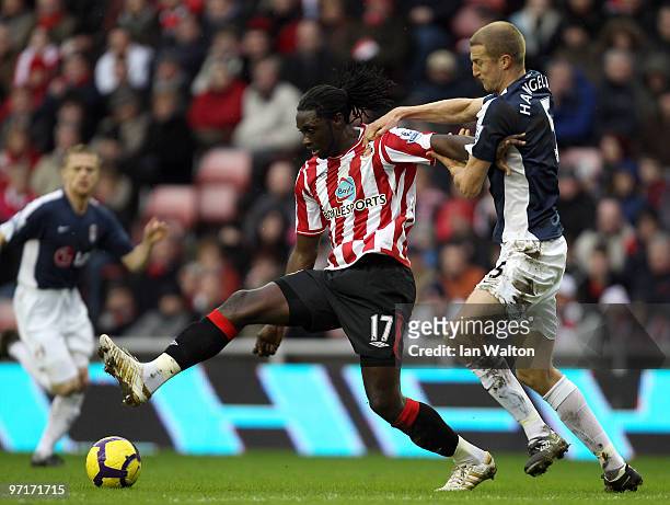 Brede Hangeland of Fulham tries to tackle Kenwyne Jones of Sunderland during the Barclays Premier League match between Sunderland and Fulham at...