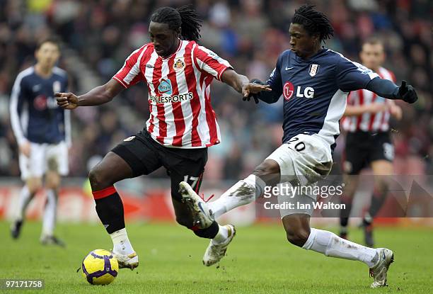 Dickson Etuhu of Fulham tries to tackle Kenwyne Jones of Sunderland during the Barclays Premier League match between Sunderland and Fulham at Stadium...