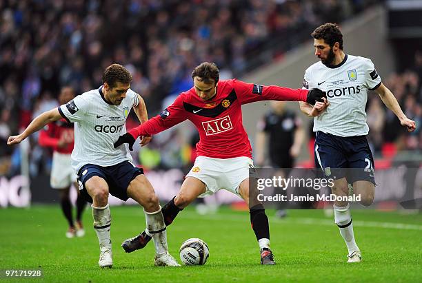 Dimitar Berbatov of Manchester battles with Carlos Cuellar and Stiliyan Petrov of Aston Villa during the Carling Cup Final between Aston Villa and...