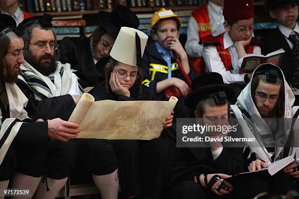 Ultra-orthodox Jews follow the reading of the Scroll of Esther during Purim festival prayers at the Vishnitz Chassidic synagogue on February 28, 2010...