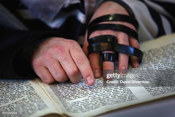 An ultra-orthodox Jew follows the reading of the Scroll of Esther during Purim festival prayers at the Permishlan Chassidic synagogue on February 28,...