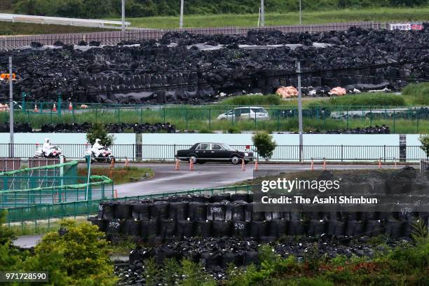 Car carrying Emperor Akihito and Empress Michiko runs on National Road No. 6 where bags containing radioactive soil are piled up on June 10, 2018 in...